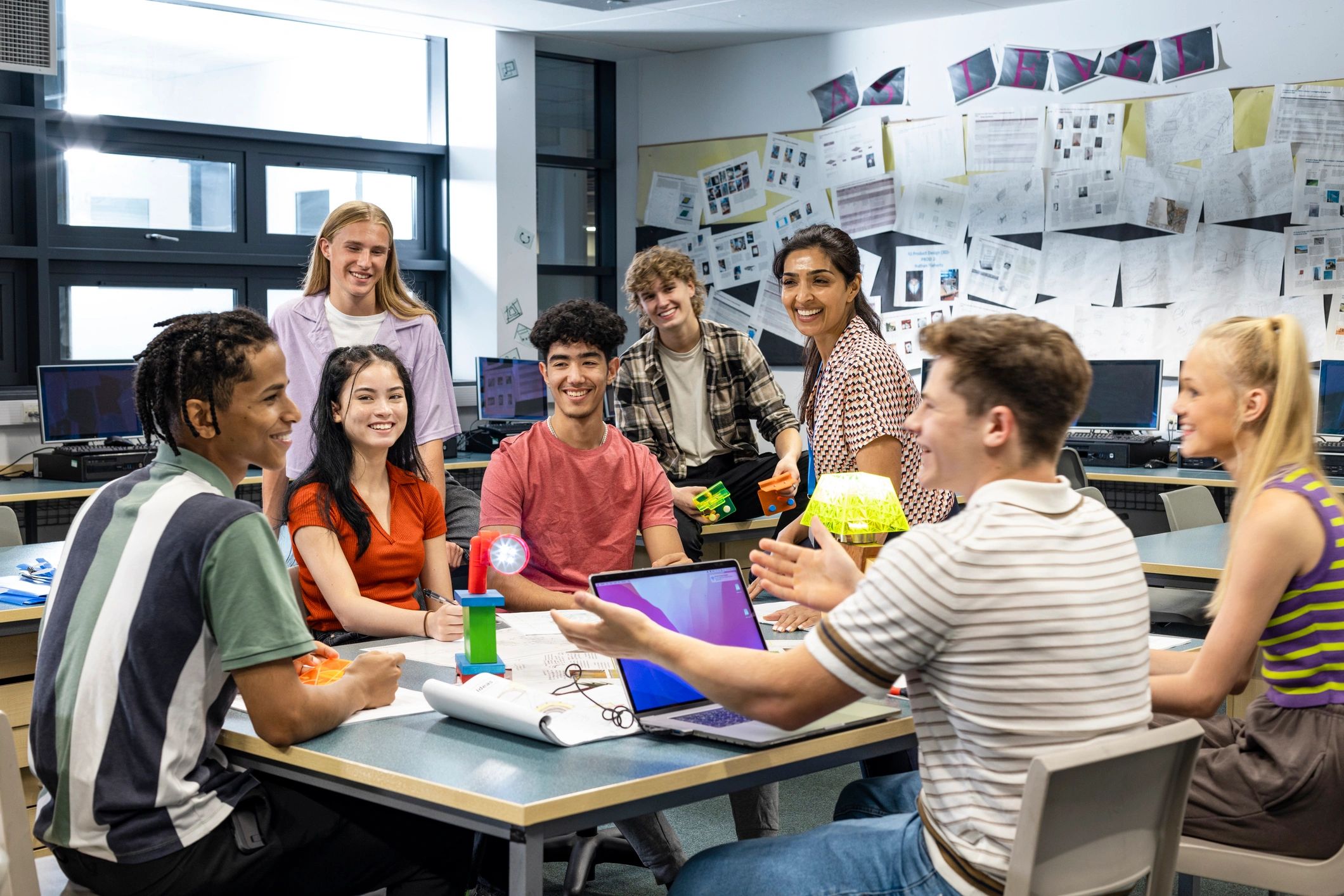 Professor e alunos reunidos em sala de aula tecnológica